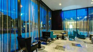 A modern lounge area with a sofa, chairs, and a coffee table.