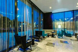 A modern lounge area with a sofa, chairs, and a coffee table. - Crystal Orange Hotel Changzhou Dinosaurs Park (Changzhou)