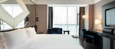 Une chambre d’hôtel avec un grand lit, un bureau, une chaise et un téléviseur.