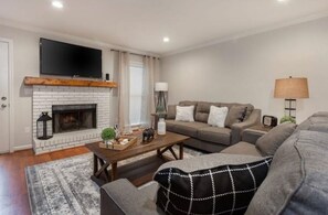 Cozy living space with a fireplace, flat-screen TV, and comfortable seating area.