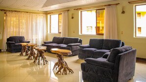 Een ruime woonkamer met banken, een salontafel en een houten tafel met een boomstamomgeving.