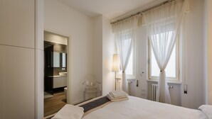 Una habitación de hotel con cama, baño y espejo.