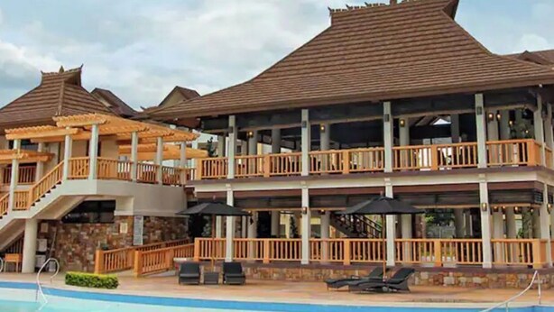 A resort with multiple buildings, a swimming pool, and outdoor seating areas. - Spacious Condo 1BR with Washer near SM Mall (Davao City)