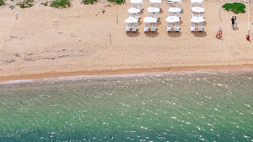 Relax on the beach with comfortable sun loungers arranged on the sandy shore.
