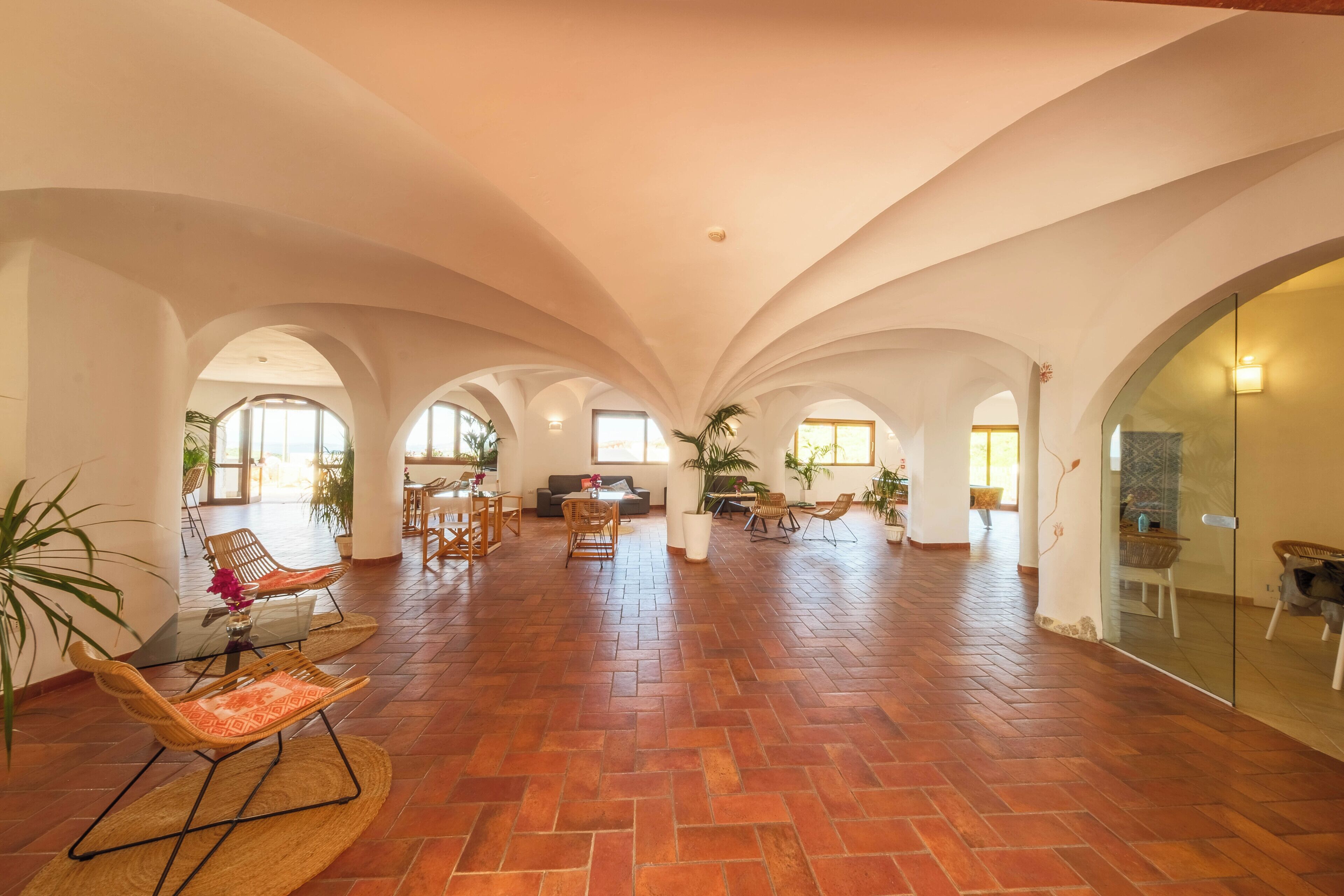 A spacious interior with arched ceilings, a tiled floor, and multiple seating areas.