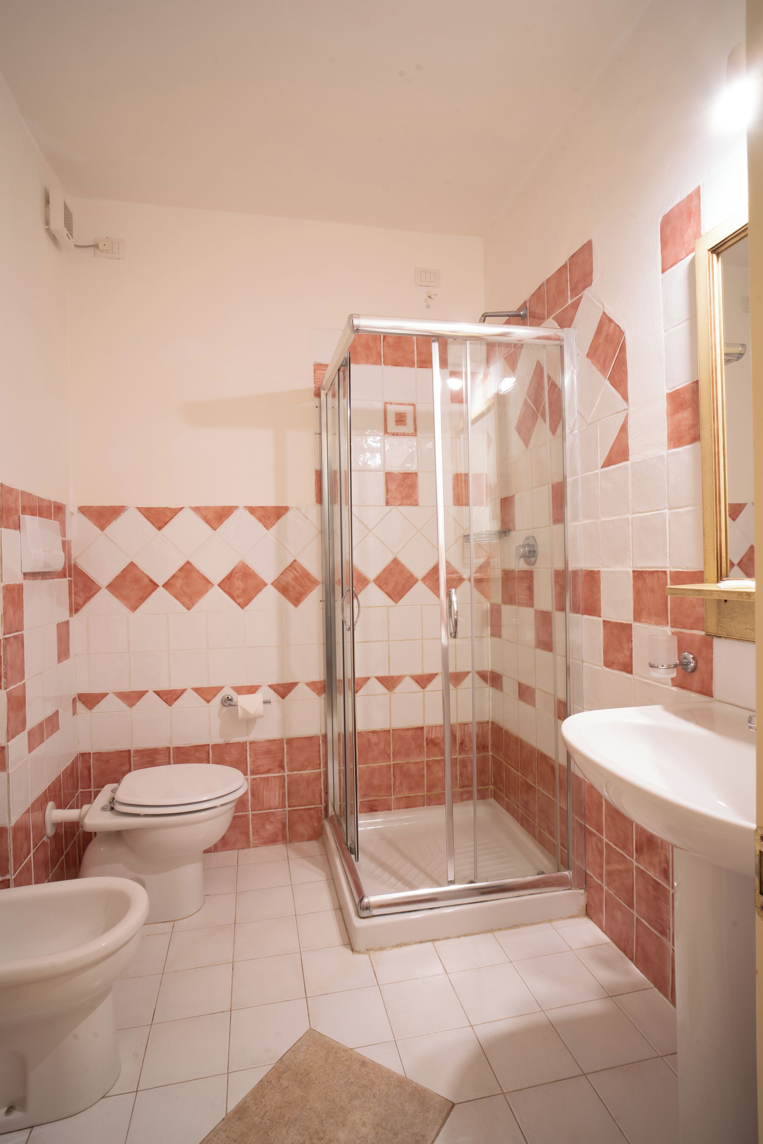 Une salle de bain équipée d’une douche, de toilettes, d’un bidet et d’un lavabo.