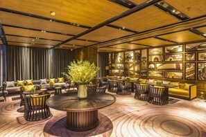 Een moderne lounge met een ronde centrale tafel, banken en stoelen eromheen geplaatst.