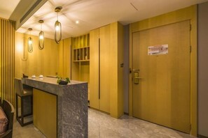 A hotel lobby with a marble reception desk, pendant lighting, and a closed door with a sign. - OffCN HY Hotel (Nanjing)