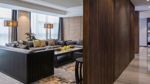 Una sala moderna con un conjunto de sofás, una mesa de centro y un jarrón decorativo.