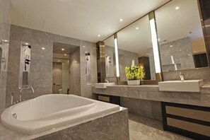 A modern bathroom with a large bathtub, two sinks, and a large mirror. - OffCN HY Hotel (Nanjing)