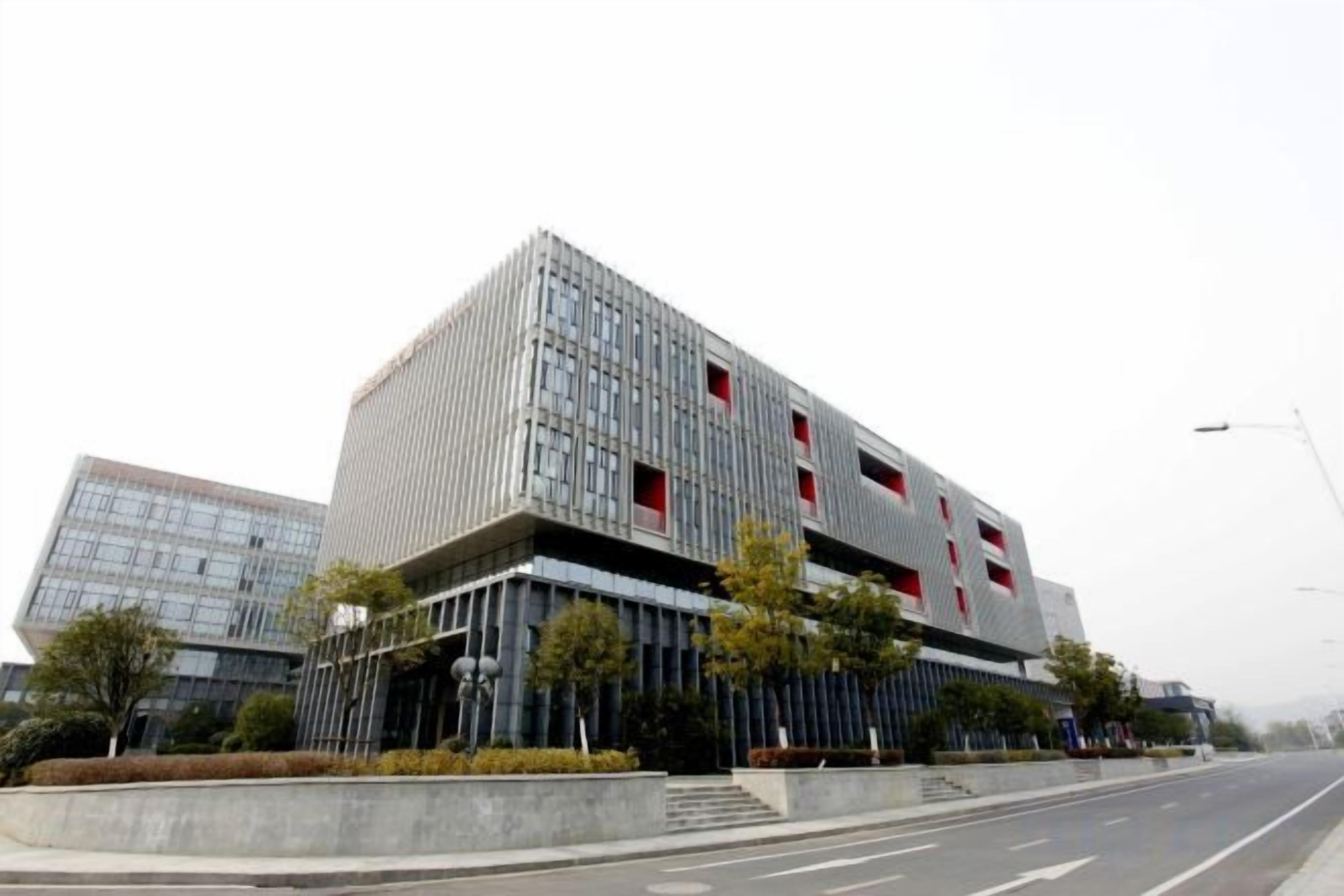 A modern building with a prominent glass facade, a flat roof, and a structured, rectangular shape.