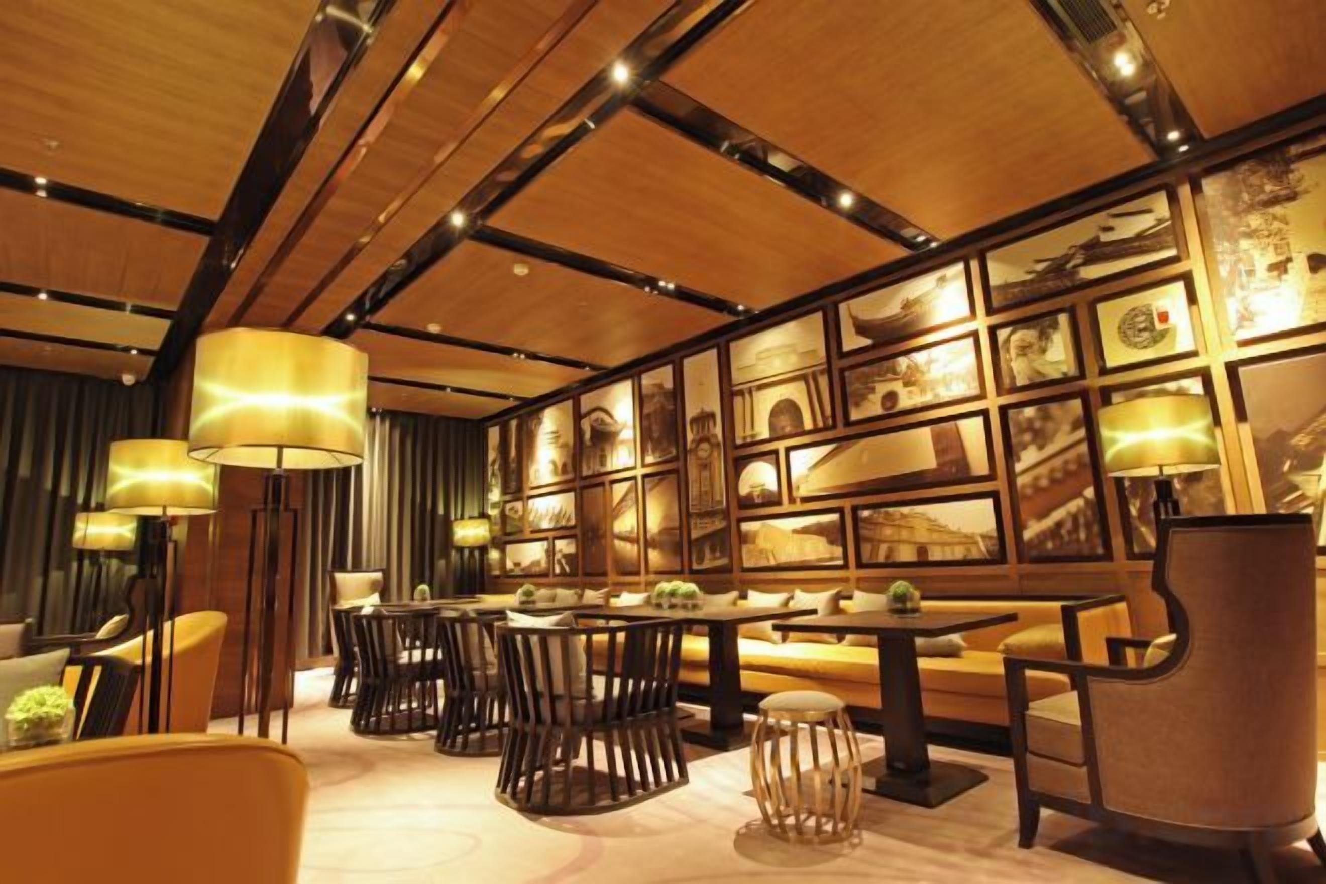 A restaurant with wooden ceiling beams, round tables, and chairs.