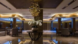 Un vestíbulo amplio con una mesa central, sillas y una planta decorativa.