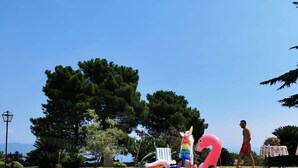 A swimming pool with inflatable flamingos and a unicorn float, surrounded by trees and a clear sky. - A True Sicilian guesthouse with Pool on Mt. Etna, perfect for Families & Groups. (Puntalazzo)