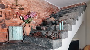 A rustic staircase with a brick wall, various antique keys, a vase with dried flowers, and a vintage sewing machine. - A True Sicilian guesthouse with Pool on Mt. Etna, perfect for Families & Groups. (Puntalazzo)