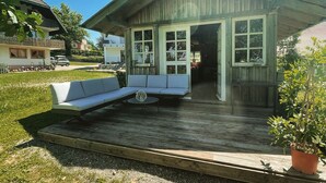 A wooden building with a porch, a bench, and a potted plant. - Family-friendly temporary home (Horben)