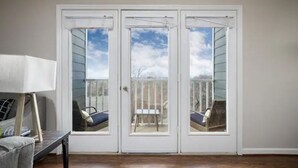 Una habitación con una puerta blanca que da a una terraza exterior.