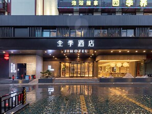 A hotel entrance with a glass facade, a reception desk, and a reflection pool in front. - JI Hotel Nanning Dongge Road (Nanning)