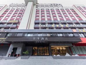Un hôtel à l’architecture moderne, avec une façade imposante et plusieurs étages, chacun étant signalé par des panneaux indiquant les différents équipements et services proposés.