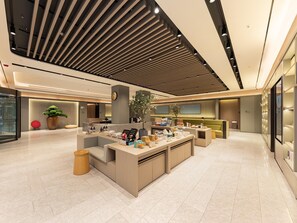 A modern lobby with a central reception desk, seating areas, and a large potted plant. - JI Hotel Nanning Dongge Road (Nanning)