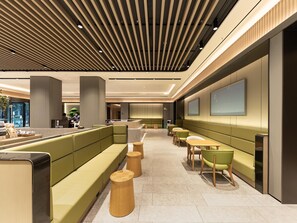 A modern hotel lobby with a reception desk, green seating areas, and a large wall-mounted TV. - JI Hotel Nanning Dongge Road (Nanning)