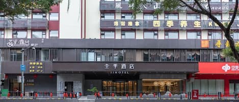 A hotel with a modern facade, a visible entrance, and a sign indicating it is a hotel.