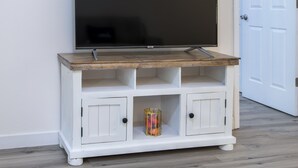 A white entertainment center with a flat-screen TV mounted above it.
