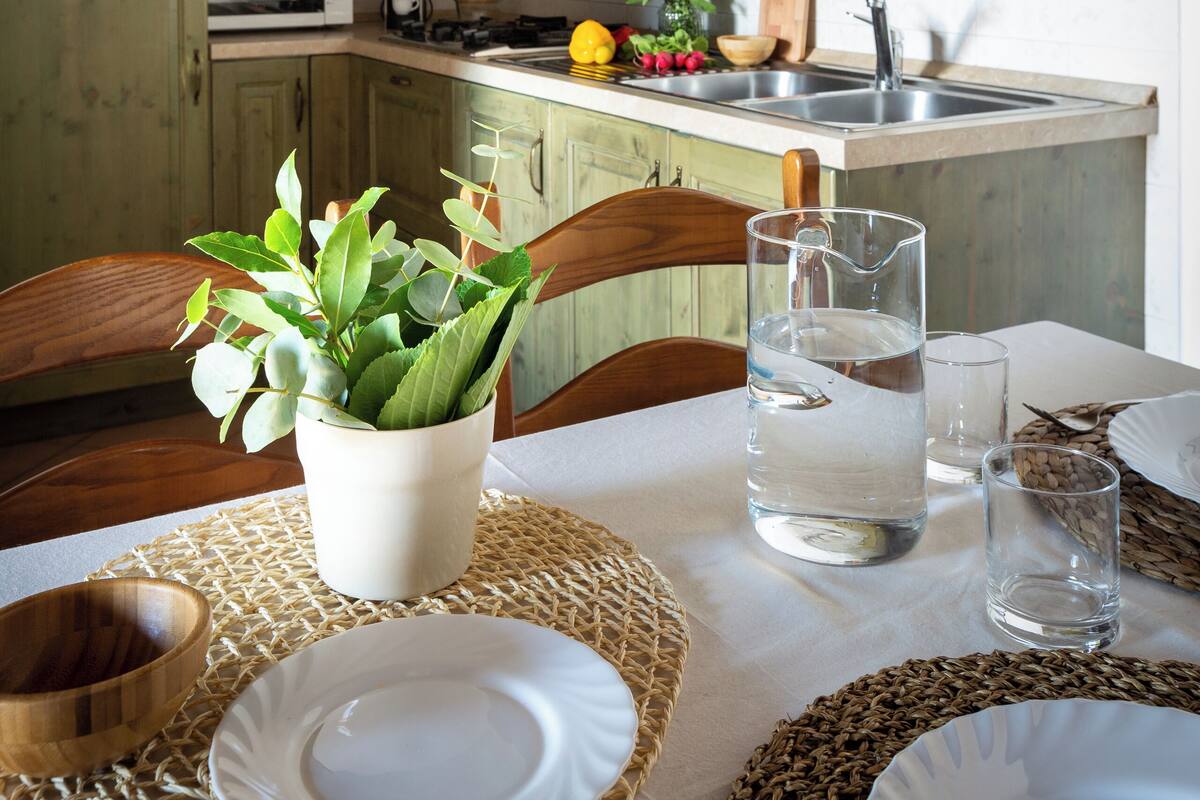 A rustic kitchen with wooden cabinets, a microwave, and a sink.