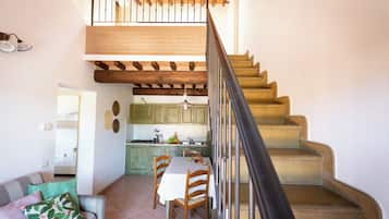 Eine Treppe führt zum Schlafzimmer auf dem Dachboden, mit Blick auf die Küche darunter.