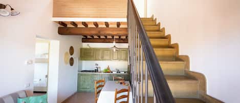 A staircase leading to a loft bedroom with a view of the kitchen below.