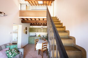 A staircase leading to a loft bedroom with a view of the kitchen below.