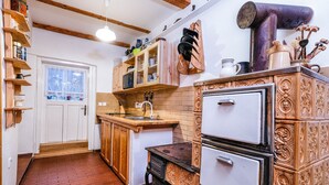 A kitchen with wooden cabinets, a sink, and a stove. - Chalupa na Fryšavě (Frysava pod Zakovou horou)