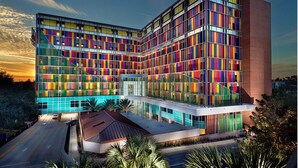 A modern building with a unique facade featuring a grid of colorful panels. - Depot Village (Gainesville)