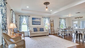 A living room with a sofa, chairs, a dining table, and a view of the outdoors. - Fairways & MLB Fun! Poolside Haven in Lehigh Acres (Lehigh Acres)