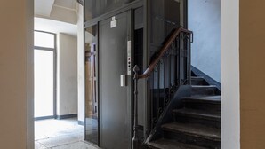 Eine Treppe mit Metallhandlauf, die zu einer Tür mit einem Schild führt.