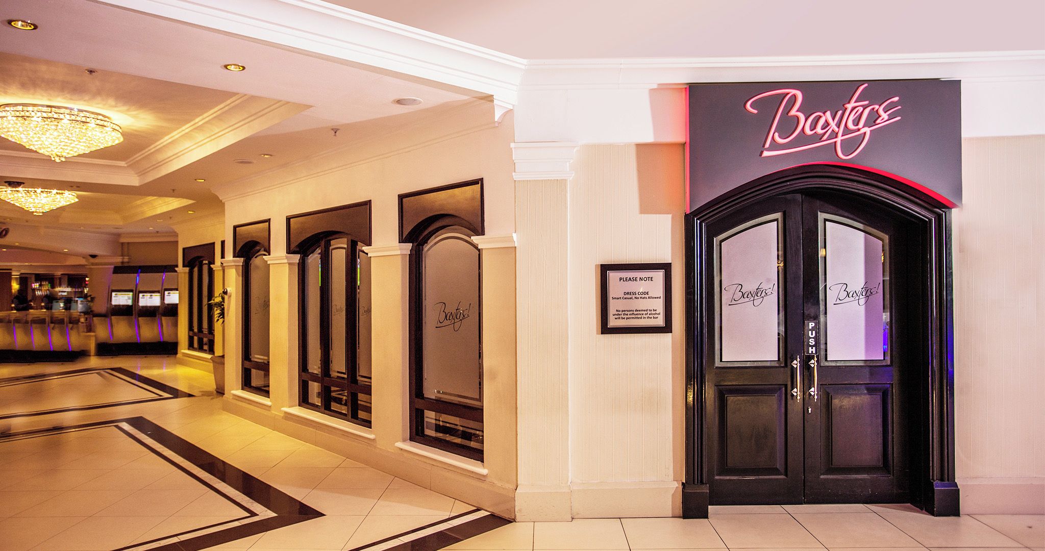 A hotel lobby with a reception area, a bar, and a push button door labeled "Bayers".