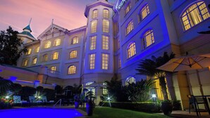 A large hotel with multiple floors, a swimming pool, and outdoor seating areas. - The Ridge Hotel (Emalahleni)