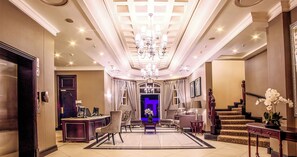 A grand lobby with a chandelier, a reception desk, and a staircase. - The Ridge Hotel (Emalahleni)