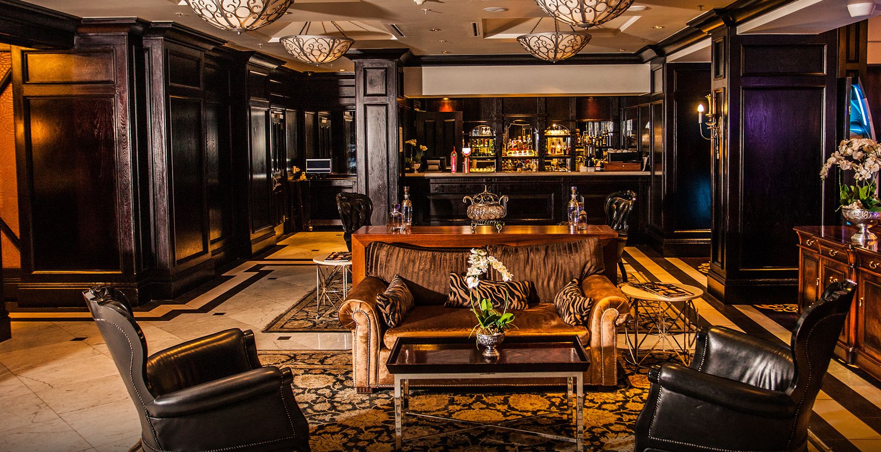 A bar area with a bar counter, seating, and a variety of bottles.