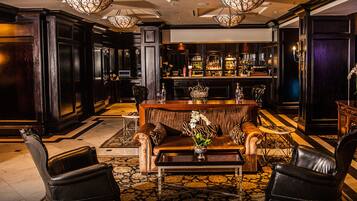 A bar area with a bar counter, seating, and a variety of bottles.
