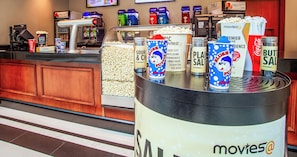 A concession stand with popcorn and movie-themed containers.