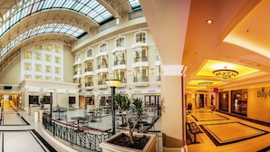 A spacious atrium with multiple floors, a central open area with seating, and a prominent restaurant named 'BillyG'. - The Ridge Hotel (Emalahleni)