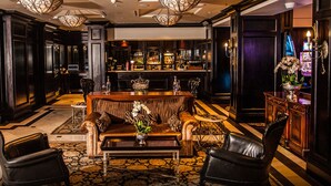 A bar area with a bar counter, seating, and a decorative vase. - The RidgePoint Hotel (Emalahleni)