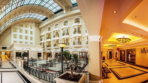 A spacious atrium with multiple floors, a central open area with seating, and a prominent restaurant named 'BillyG'. - The RidgePoint Hotel (Emalahleni)
