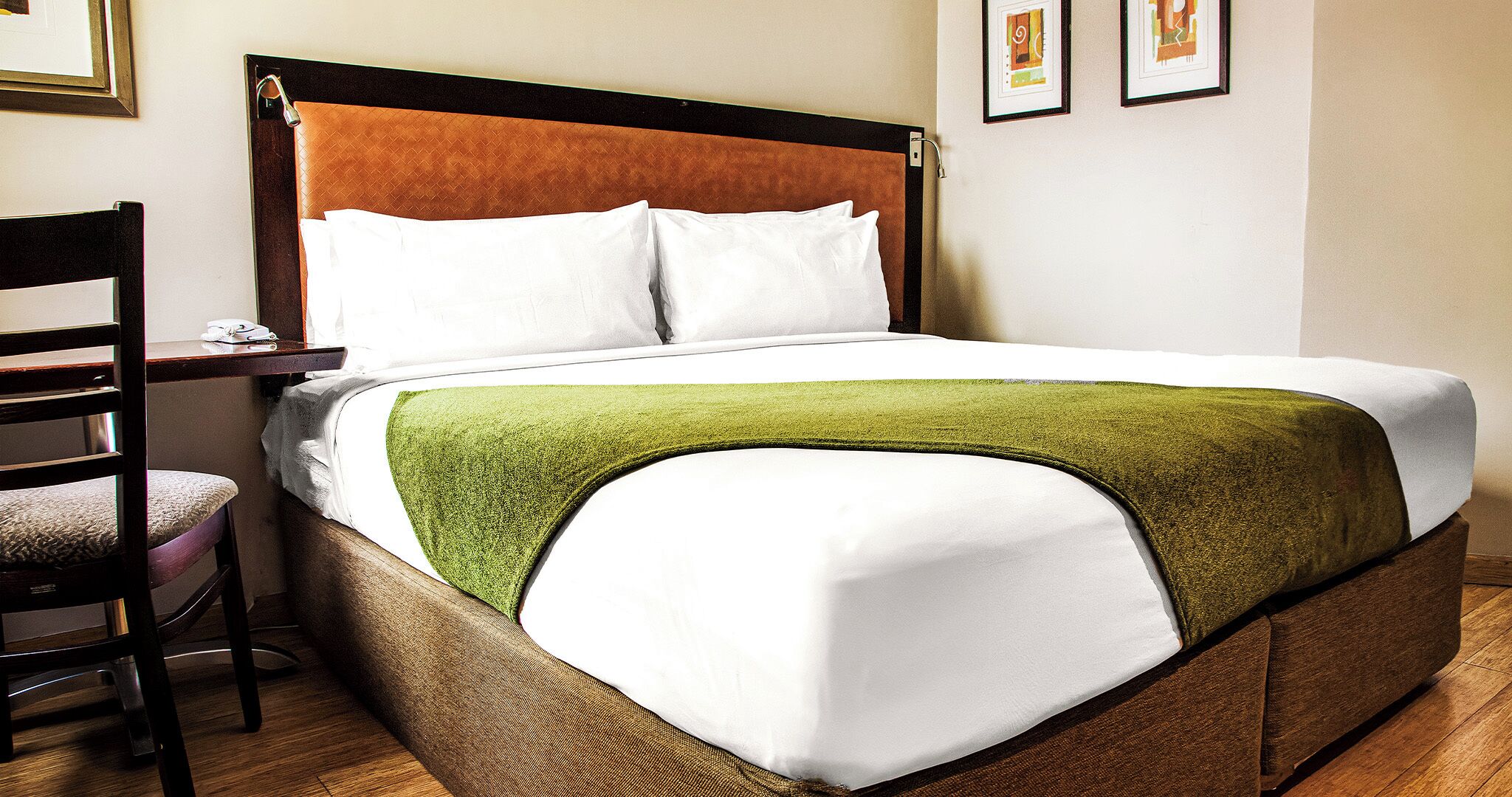 A hotel room with a bed, a chair, and a nightstand.