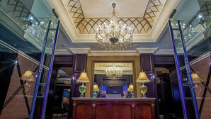 A grand lobby with a large chandelier, a reception desk, and a mirrored wall. - The RidgePoint Hotel (Emalahleni)