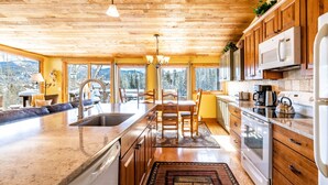 A kitchen with wooden cabinets, a stainless steel sink, and a large island with seating.