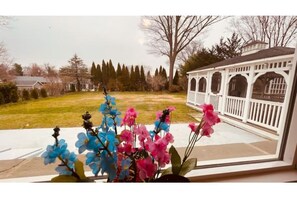 Enjoy a serene view from this room's window overlooking a beautifully maintained lawn and classic gazebo.