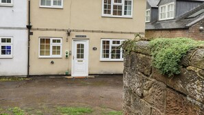 A two-story building with a white door labeled "Riverbank View" and the number "12" above it. - Riverbank View (Whitby)
