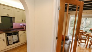 A kitchen with white cabinets, a wooden countertop, and a built-in oven. - Riverbank View (Whitby)